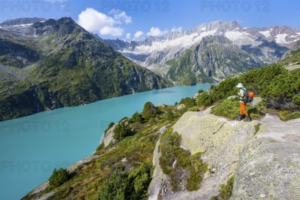 Mountaineers in front of picturesque mountain landscape, turquoise-blue mountain lake Göscheneralpsee, Dammastock and Damma Glacier, Göscheneralp, Canton of Uri, Switzerland
