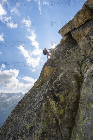 Female mountaineer on steep rock face on the secured via ferrata Krokodil-Bergsee am Bergseeschijen-Vorbau, Sonnenstern, Göscheneralp, Canton of Uri, Switzerland