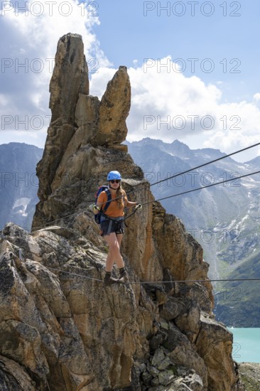 Crocodile rock formation, mountaineer on rope bridge in the Crocodile Mountain Lake via ferrata on Bergseeschijen-Vorbau, Göscheneralp, Canton of Uri, Switzerland