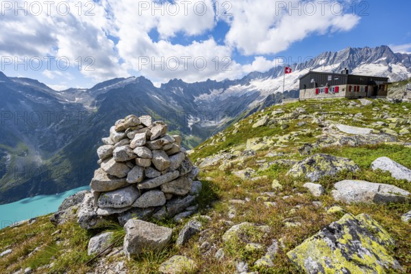 Mountain hut BergseehÃ¼tte with Swiss flag in picturesque mountain landscape, view of Damma Glacier and Dammastock, GÃ¶scheneralp, Canton of Uri, Switzerland