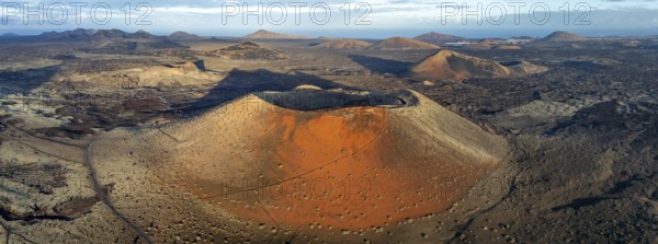 Caldera Colorada volcano, picturesque volcanic landscape with volcanic craters and lava fields in morning light, Parque Natural de Los Volcanes, aerial view, Lanzarote, Canary Islands, Spain
