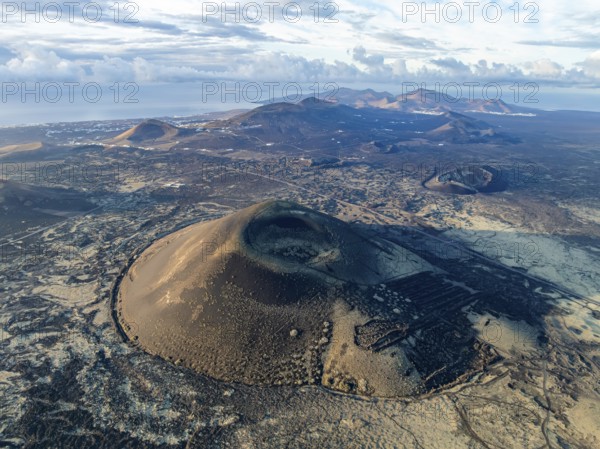 MontaÃ±a Negra volcano, picturesque volcanic landscape with volcanic craters and lava fields in morning light, Parque Natural de Los Volcanes, aerial view, Lanzarote, Canary Islands, Spain