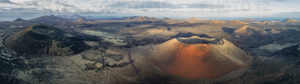 Caldera Colorada volcano and MontaÃ±a Negra, picturesque volcanic landscape with volcanic craters and lava fields in morning light, Parque Natural de Los Volcanes, aerial view, Lanzarote, Canary Islands, Spain