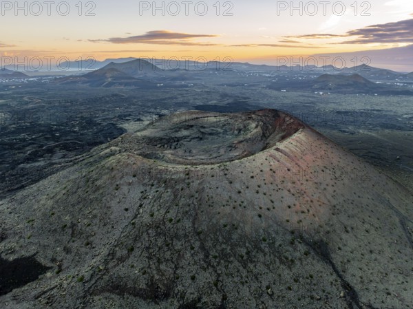 Caldera Colorada volcano, picturesque volcanic landscape with volcanic crater at sunrise, Parque Natural de Los Volcanes, aerial view, Lanzarote, Canary Islands, Spain