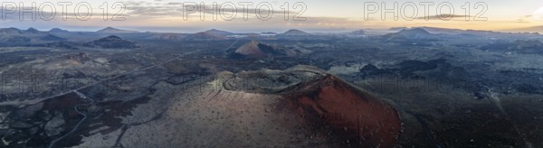 Caldera Colorada volcano, picturesque volcanic landscape with volcanic craters at sunrise, Los Volcanes Natural Park, aerial view, Lanzarote, Canary Islands, Spain
