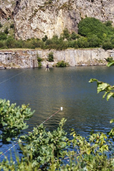 Tourist on a zip line across the lake, Opal Lake in the granite quarry, MoselleÃ¸kken Stenbrudsmuseum, museum in the quarry, Hammerknuden, Allinge-Sandvig, Bornholm, Denmark