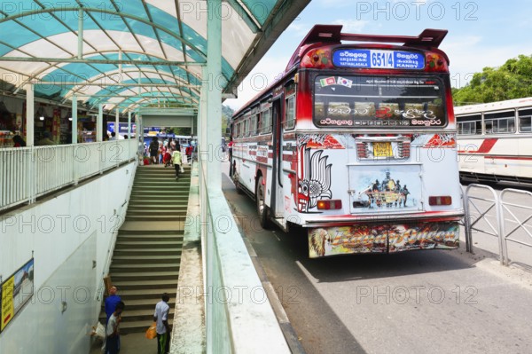 Fully decorated buses passing near an underground passage, Kandy, Sri Lanka