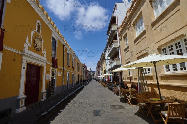 Bustling old town street with cafés and yellow buildings, UNESCO World Heritage Old Town of San Crstobal de La Laguna, La Laguna, Tenerife, Canary Islands, Spain