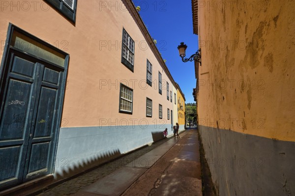 Narrow old town alleyway with pastel-colored houses and decorative alleyway lights, UNESCO World Heritage Old Town of San Crstobal de La Laguna, La Laguna, Tenerife, Canary Islands, Spain