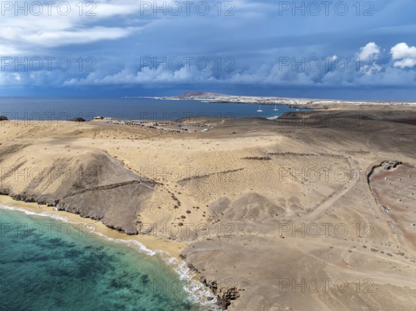 Coast with Playa Caleta del Congrio beach and blue sea, arid landscape of Los Ajaches Natural Park, aerial view, Lanzarote, Canary Islands, Spain