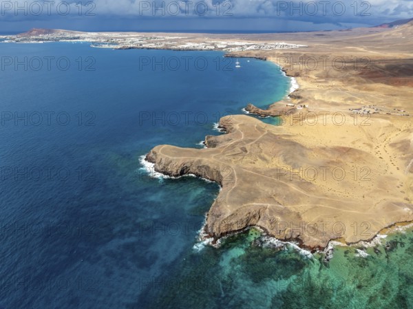 Coast with Playa de Papagayo beach and blue sea, arid landscape of Los Ajaches Natural Park, aerial view, Lanzarote, Canary Islands, Spain