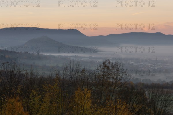 The majestic Teck Castle towers over the fog in the foothills of Alb. Aichelberg View of Teck Castle and Limburg in autumn