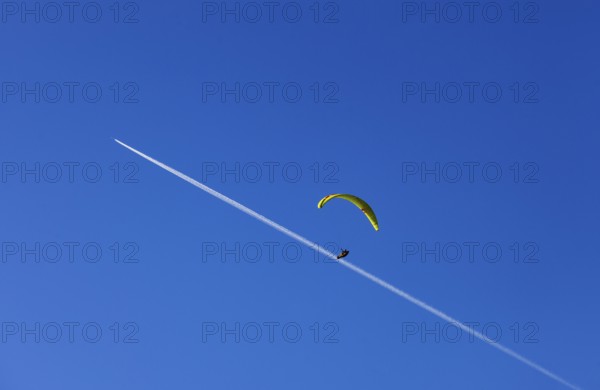 Paragliders with contrails in the blue sky, Osterhorn Group, Salzkammergut, Province of Salzburg, Austria