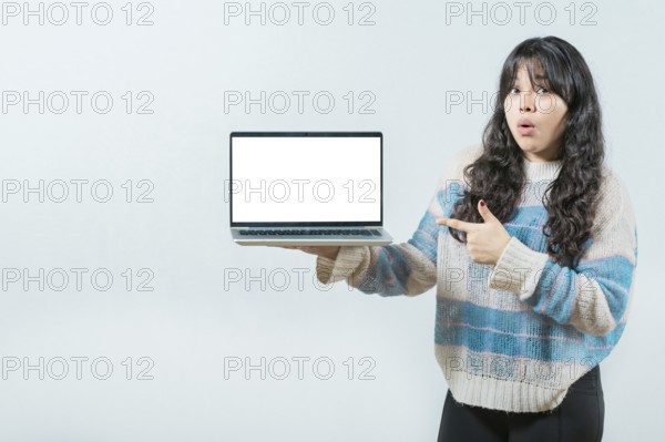 Surprised Young Asian woman displaying a promotion on laptop screen. Portrait of beautiful asian girl showing laptop screen isolated