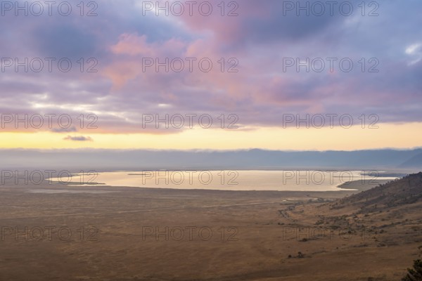 View of savanna landscape and Magadi Lake at sunrise, atmospheric morning light, view of Ngorongoro Crater, Ngorongoro Conservation Area, Tanzania
