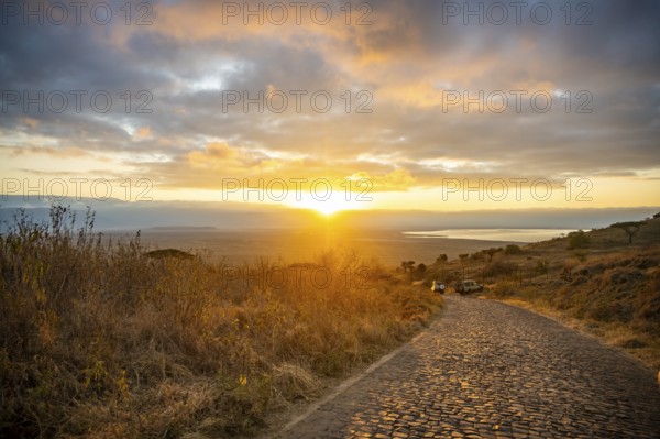 Road leading into Ngorongoro Crater, at sunrise, atmospheric morning light, view of Ngorongoro Crater, Ngorongoro Conservation Area, Tanzania