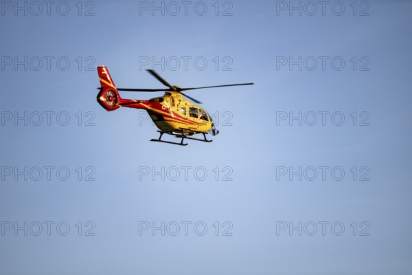 Rescue helicopter flying against a blue sky, Tyrol, Austria