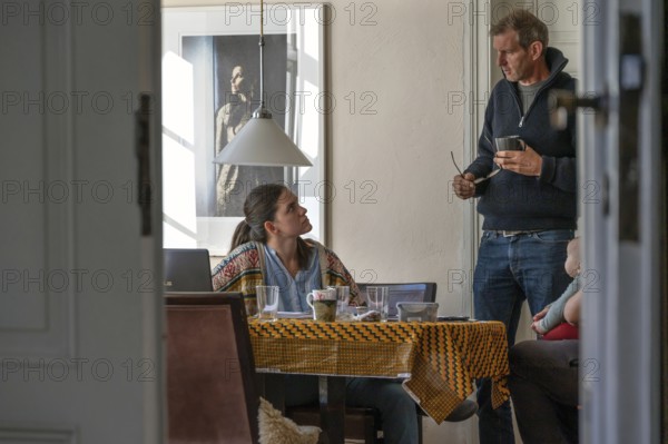 Home office, father and daughter working at the breakfast table, grandchild on the right, Mecklenburg-Western Pomerania, Germany