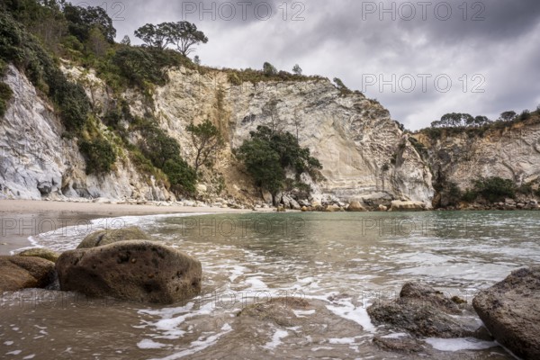 Landscape with sea, sandy beach, rocks and cliffs in New Zealand. Stingray Bay, Coromandel Peninsula, Waikato, New Zealand