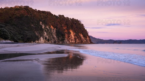 Landscape with sea and sandy beach in New Zealand. Hahei Beach at sunrise in the morning. Hahei, Coromandel Peninsula, Waikato, New Zealand