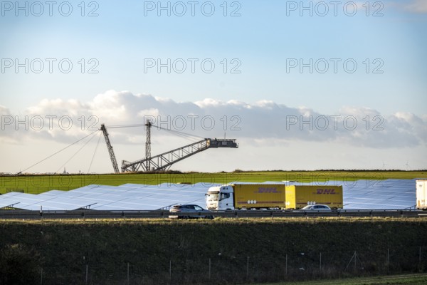 86.5 MW peak open space photovoltaic systems, from RWE, with over 141, 000 solar modules, on a side strip, along the A44 motorway near JÃ¼chen, on the timber triangle, recultivated open-cast mining site, excavator in the Garzweiler lignite mine, North Rhine-Westphalia, Germany