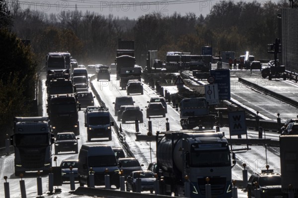 Highway construction site, the A57 is extended to 6 lanes on the section between the Meerbusch motorway junction and the Oppum junction, traffic runs parallel to 2 narrowed lanes, wet road after rain shower, Krefeld, North Rhine-Westphalia, Germany