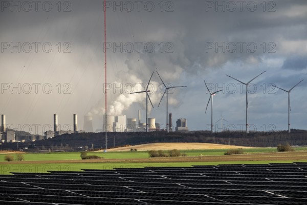 86.5 MW peak open space photovoltaic systems, from RWE, with over 141, 000 solar modules, on a side strip, along the A44 motorway near JÃ¼chen, at the timber triangle, recultivated open-cast mining site, in the background RWE Neurath lignite power plant, wind farm, North Rhine-Westphalia, Germany