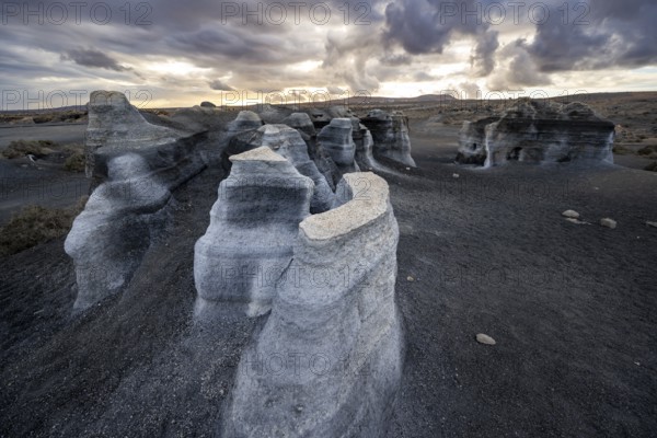Eroded rock formations, volcanic landscape with dramatic cloudy sky at sunset, Ciudad Estratificada or Los Roferos, Antigua Rofera de Teseguite, Lanzarote, Canary Islands, Spain