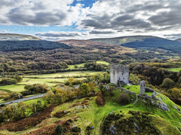 Autumn colours over Castell Dolwyddelan and Eryri Mountains from a drone, Snowdonia, Conwy County Borough, Wales, England, United Kingdom