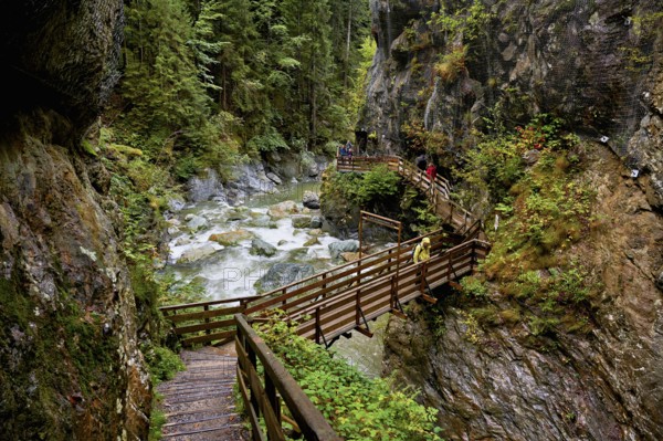 People on wooden walkway on the Diosaz mountain river in the gorge, Gorges de la Diosaz, Les Houches, Chamonix-Mont-Blanc, Haute-Savoie, France