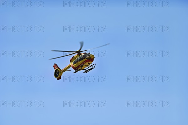 Helicopter flying against a blue sky, alpine rescue, mountain rescue, Chamonix, Haute-Savoie, France
