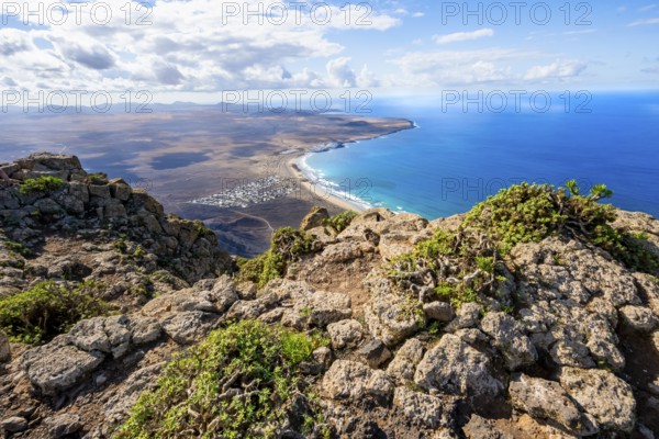 Castillejo viewpoint, view from the Risco de Famara cliffs to the coast and the sea with Famara beach, Playa de Famara with La Calaeta, Lanzarote, Canary Islands, Spain