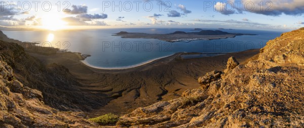 View of steep cliffs to sea and the island of La Graciosa, Mirador del Porrito viewpoint at sunset, Lanzarote, Canary Islands, Spain