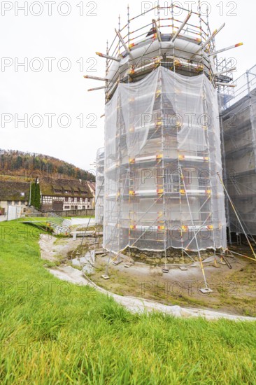 Large tower in scaffolding with surrounding meadow, trees and buildings in the background, Wasserschloss Glatt, Sulz, Germany