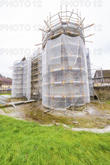 Armored building in rural area with tarpaulins, surrounded by autumn vegetation, Wasserschloss Glatt, Sulz, Germany