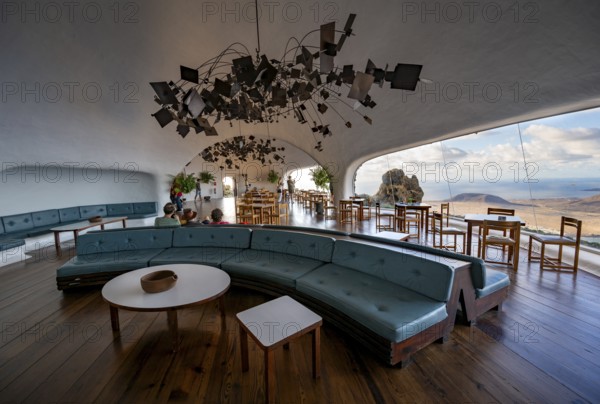 Sitting area with large sofa in the cafe with panoramic window, interior at the Mirador del RÃ­o viewpoint, designed by artist César Manrique, Lanzarote, Canary Islands, Spain