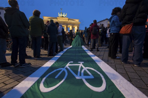 Athena Macke (costume designer) wears a dress with a long train in the shape of a bike path (bike path dress) at the international climate demo under the motto Fight for 1.5 at the Brandenburg Gate in Berlin on 14.11.2025. The demonstration takes place on the occasion of the COP30 World Climate Conference in Belém, Brazil, and to mark 10 years of the Paris Climate Agreement
