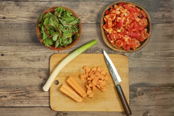 Preparation of fresh vegetables on a wooden cutting board for a healthy salad