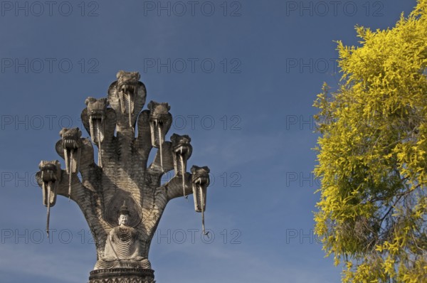 Monumental depiction of Buddha meditating under the protection of a seven-headed naga snake, Wat Khaek, also Sala Kaew Ku sculpture park, Nong Khai, Thailand