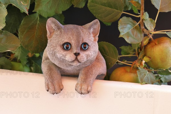 Ceramic cat looking intently in a garden, Wilnsdorf, North Rhine-Westphalia, Germany