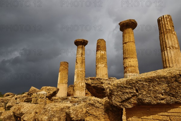 Temple of Heracles, Five ancient columns against dark, looming clouds, Valley of the Temples, Valle dei Templi, Archaeological Site, UNESCO World Heritage Site, Agrigento, Sicily, Italy