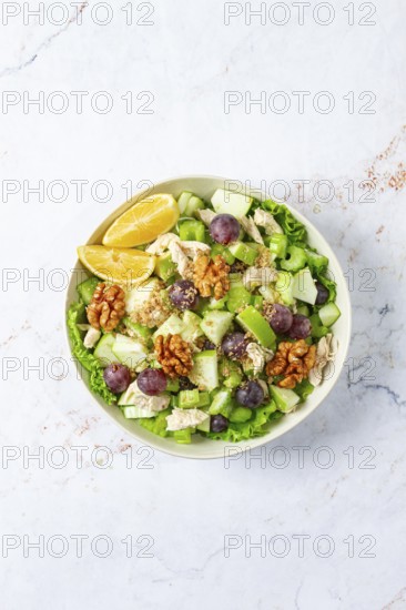 Fresh Waldorf salad, celery stalk with chicken, apple and walnuts, grapes, herbs, homemade, without people
