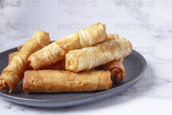 Fried spring rolls with cheese, on a plate, with cream sauce, no people