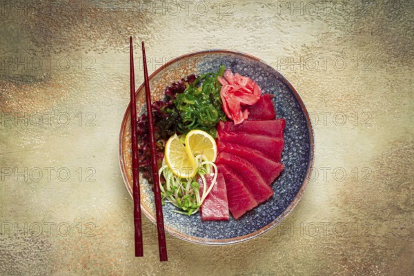 Tuna sashimi with daikon and wakame salad, pickled ginger, in a bowl