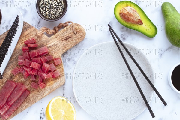 Cooking fresh tuna with ingredients on a marble countertop, ingredients for making sushi and tuna tartare