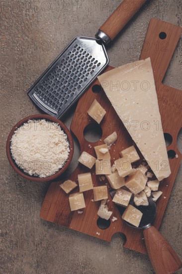 Freshly sliced and grated cheese, parmesan cheese, Gran gusto. Grana padano. on a wooden chopping board, rustic style, no people