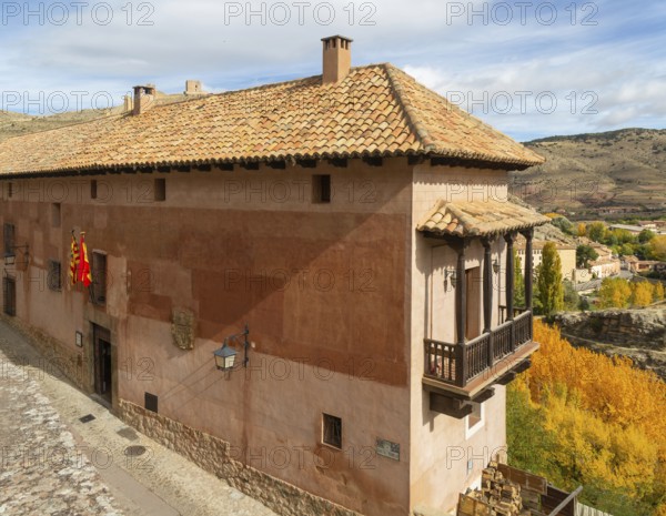 Alberque hostel building with flags flying, historic buildings in medieval village of AlbarracÃ­n, Teruel province, Aragon, Spain