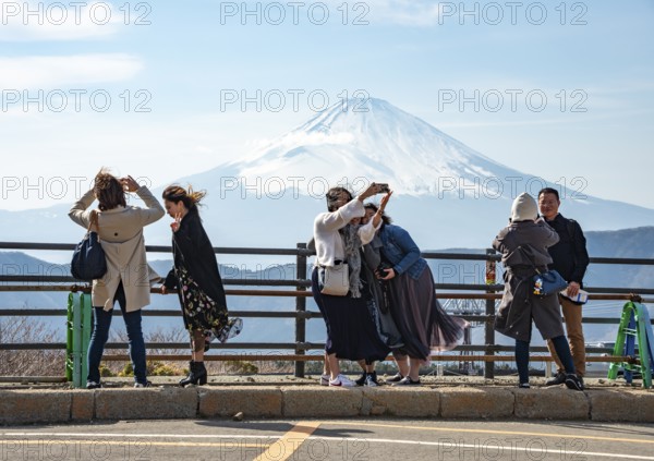 Tourists enjoy the view and take pictures, view of the snow-covered summit of Mount Fuji volcano in spring, ÅŒwakudani, Hakone, Japan