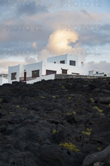 Typical white houses in the town of La Santa, at sunset, black volcanic rocks, Lanzarote, Canary Islands, Spain