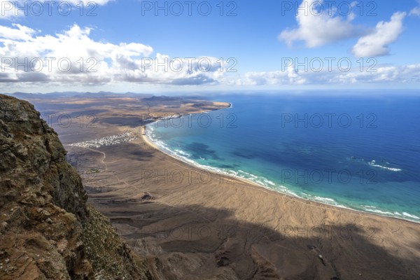 View from the Risco de Famara cliffs to the coast and the sea with the Famara beach, Playa de Famara, Lanzarote, Canary Islands, Spain